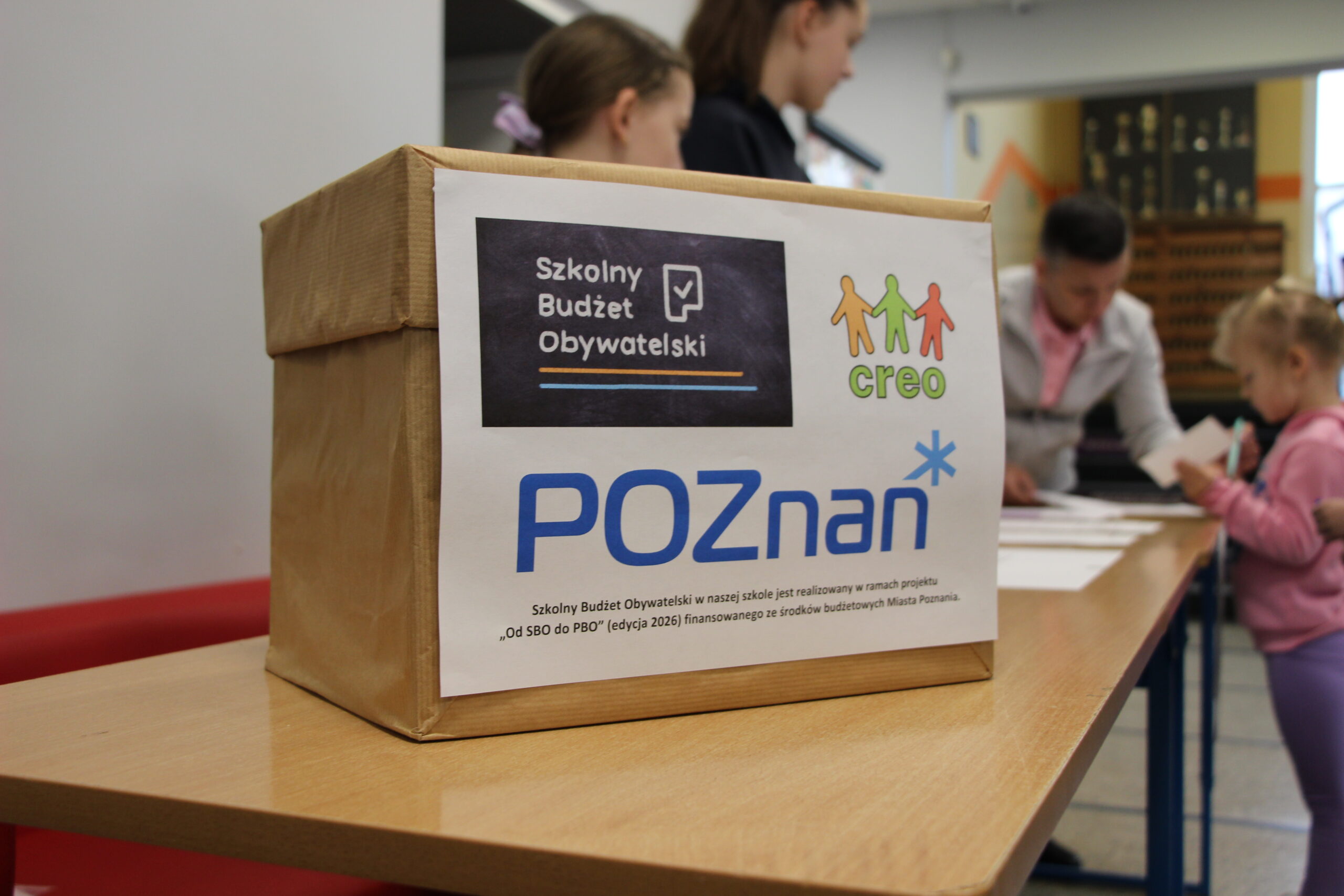 Zdjęcie przedstawia uczniów oddających głosy.